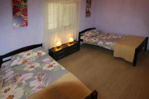 a bedroom with two beds and a window at Holiday house Lovre in Prapatnica +35 photos