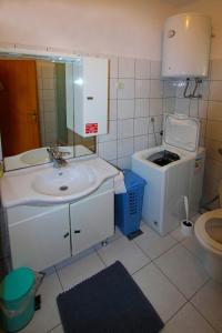 a small bathroom with a sink and a toilet at Holiday house Lovre in Prapatnica
