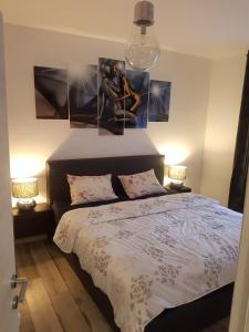 ein Schlafzimmer mit einem Bett mit drei Bildern an der Wand in der Unterkunft Seaview Apartment Moritz in Senj