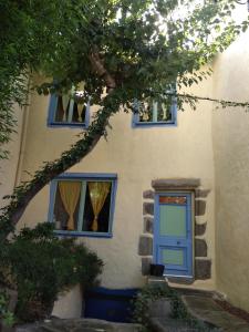 Chez Gillou في Boën: منزل فيه باب ازرق و نافذتين