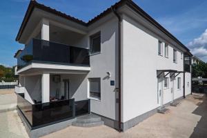 biały budynek z dużym oknem w obiekcie Apartments Talić Fažana w Fažanie