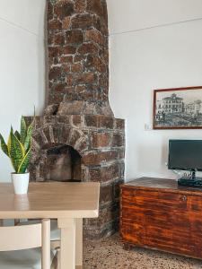 Una chimenea de ladrillo en una habitación con una mesa de madera. en La Casa Sul Tramonto en Pantelleria