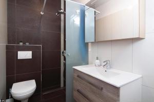 łazienka z umywalką, toaletą i prysznicem w obiekcie Apartments Talić Fažana w Fažanie