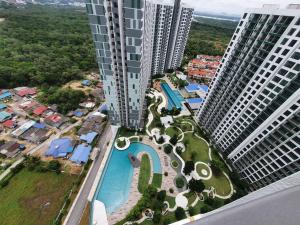 uma vista aérea de uma piscina no meio de dois edifícios altos em JB Perling New Cozy Studio em Johor Bahru