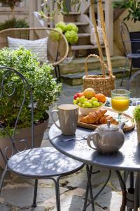 a table with a tray of food on a patio at Hôtel Le Fer à Cheval in Trouville-sur-Mer