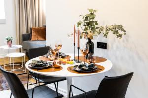 uma mesa de jantar com cadeiras e uma mesa com copos de vinho em Bob W Duo Lofts em Tartu