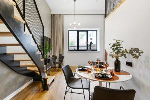 a dining room with a table and chairs and a staircase at Bob W Duo Lofts in Tartu