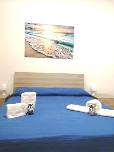 a bedroom with a bed with blue sheets and towels at Casa vacanze SALENTO BELLA VISTA in Capilungo