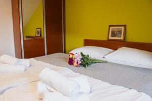 two beds with towels and a bouquet of flowers on them at Odmorište Luna in Olovo