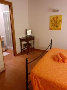 a bedroom with a bed and a desk with a laptop at Il Poggio da Leo in Capanne