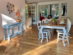 una cucina e una sala da pranzo con tavolo e sedie di Cottage Uylenhorst, De Witte Bergen 34 a IJhorst
