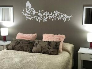 - une chambre avec un lit et un mur orné d'une fresque florale dans l'établissement PETIT RIVADAVIA en el corazón de Mendoza, à Mendoza
