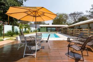 阿拉拉夸拉Espaço Barão - Área de Lazer的带桌椅和遮阳伞的露台