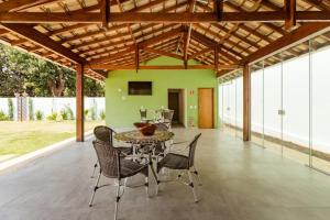 une terrasse avec une table, des chaises et un mur vert dans l'établissement Espaço Barão - Área de Lazer, à Araraquara