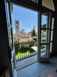 una puerta abierta a un balcón con una torre de reloj en LA FINESTRA Charme & Relax, en Bérgamo
