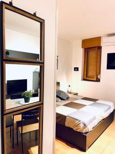 1 dormitorio con cama, escritorio y espejo en RobertONE guest house 14, en Bari