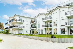 a large white apartment building with a courtyard at Ewigsmoi in Kühlungsborn