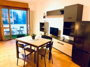 a kitchen with a table with chairs and a television at RobertONE guest house 14 in Bari