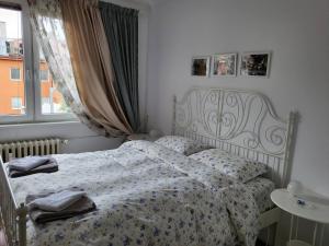 a bedroom with a bed with a floral blanket and a window at CasaBella Apartment in Sofia