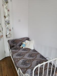 una cama blanca con un osito de peluche sentado en ella en CasaBella Apartment en Sofía