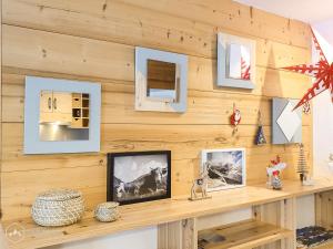 een houten muur met foto's op een plank bij Gîte de la Loza in Sollières-Sardières