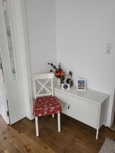 uma secretária branca com uma cadeira e flores em CasaBella Apartment em Sófia