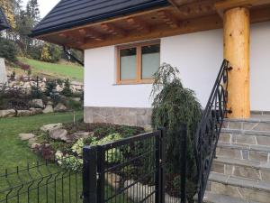 a house with a black fence and a window at Dom między górami in Bukowina Tatrzańska