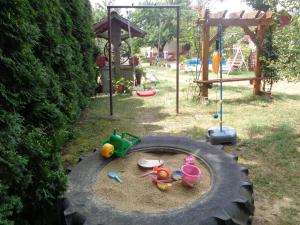 a play area with toys in a large tire at Irénke Vendégház in Alsópáhok