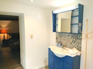 een badkamer met een blauwe wastafel en een spiegel bij 1001 Nuits in Aywaille