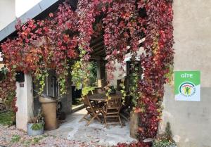 a pergola with a table and a bunch of flowers at Le Valtinet, séjour esprit montagne in Le Valtin