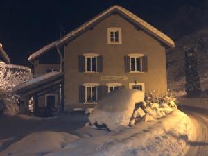 a house with a pile of snow in front of it at Le Valtinet, séjour esprit montagne in Le Valtin
