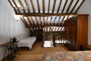 a attic room with a bed and a wooden ceiling at Rustico nel Parco Nazionale in Ronco Canavese