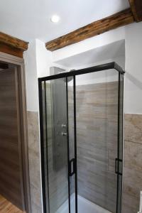 a glass shower in a bathroom with a wooden wall at Rustico nel Parco Nazionale in Ronco Canavese