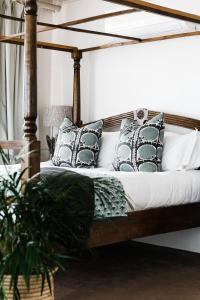 ein Schlafzimmer mit einem Holzbett mit Kissen in der Unterkunft Royal Boutique Hotel in Kapstadt