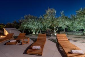 un groupe de bancs assis sur un patio la nuit dans l'établissement Villa Dalmata, à Trogir