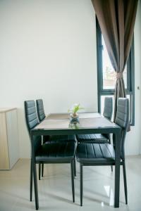 mesa de comedor con sillas negras y ventana en บ้านคุณพระ แอท รพ.กรุงเทพ, en Suratthani