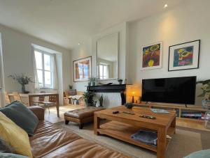 a living room with a couch and a coffee table at Appartement et parking privatif le long de l Escaut in Tournai