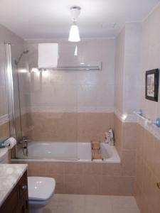 y baño con bañera, aseo y lavamanos. en Apartamento Sarrato IV de Sallent, en Sallent de Gállego