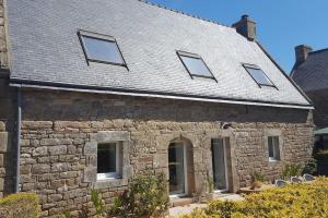 a stone house with six windows on it at La maison du village in Ploemel