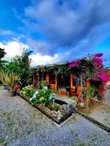 a house with flowers on the side of it at Cabañas San Miguel in Palmira