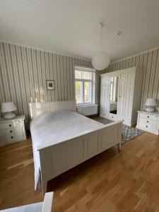 a bedroom with a large white bed and wooden floors at Pühajärve residents in Otepää