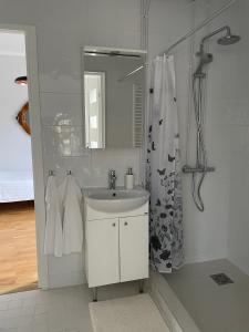 a white bathroom with a sink and a mirror at Pühajärve residents in Otepää