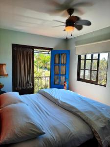 a bedroom with a large bed with a ceiling fan at Cabañas San Miguel in Palmira