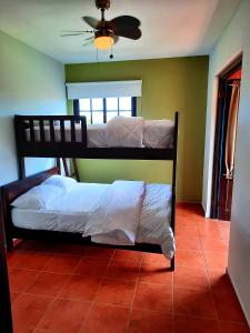 two bunk beds in a room with a ceiling fan at Cabañas San Miguel in Palmira