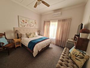 sypialnia z łóżkiem i wentylatorem sufitowym w obiekcie The Garden Inn Guesthouse w mieście Modimolle