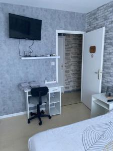 a bedroom with a desk and a chair and a tv at Les 4 M in Gercourt-et-Drillancourt