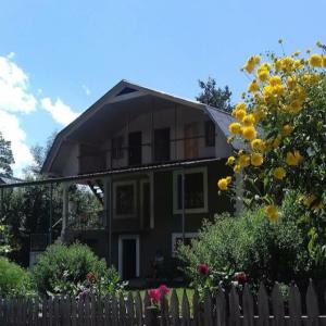 ein Haus mit einem Zaun und Blumen davor in der Unterkunft Green House Nakra in Naki