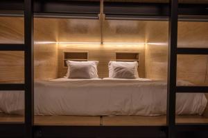 a bunk bed with two pillows on top of it at GiG Capsule Hostel in Ericeira