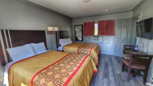 Habitación de hotel con 2 camas y mesa en Rock Haven Motel, en Asheville