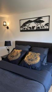 - une chambre avec un lit bleu et 2 oreillers dans l'établissement Le Troglo'Gîte, 500m à pied du Zoo de Beauval, à Seigy
